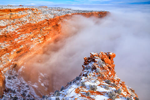 a photo of canyons filled with fog as viewed from buck canyon overlook in canyonlands national park utah near moab