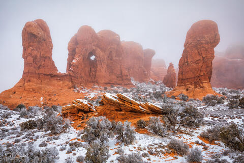 a photo of fog drifting through the parade of elephants area of arches national park near moab utah