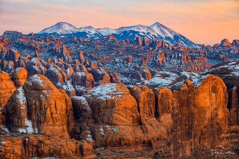 the la sal mountains and behind the rocks at sunset near moab utah.