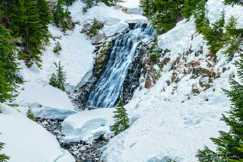 a photo of razor hone creek flowing over a waterfall in snow in washington