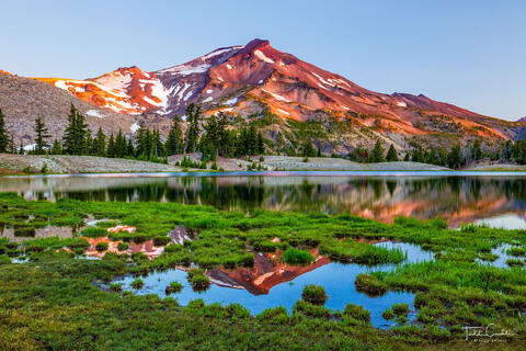 a photo of the south sister reflecting in Green Lake at sunrise in the three sisters wilderness of oregon