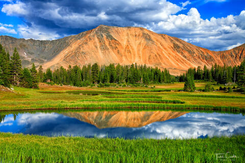 a photo of mount cumulus in the never summer range in colorado reflecting in a small tarn
