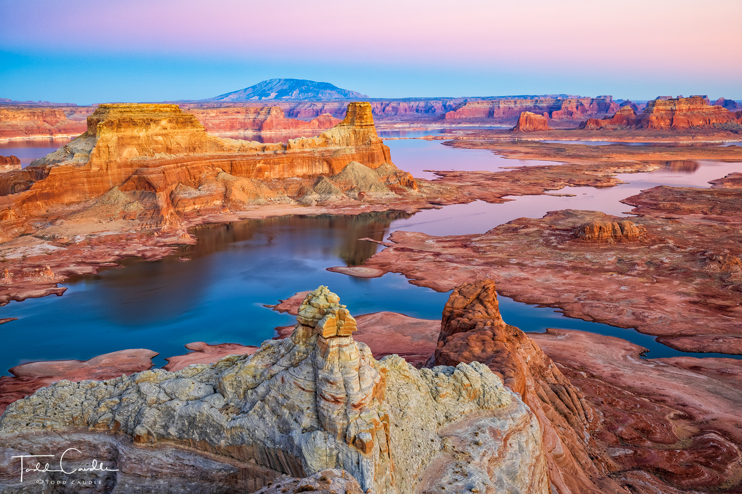 Gunsight Butte rises from the dark waters of Lake Powell as the Earth's shadow climbs skyward just after sunset.