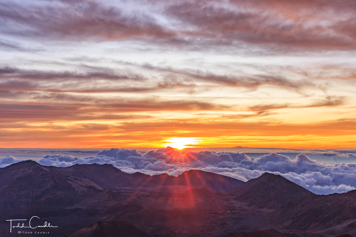 The sun rises over a sea of clouds on the flanks of Halaeakala, a 10,023-foot-high volcano.