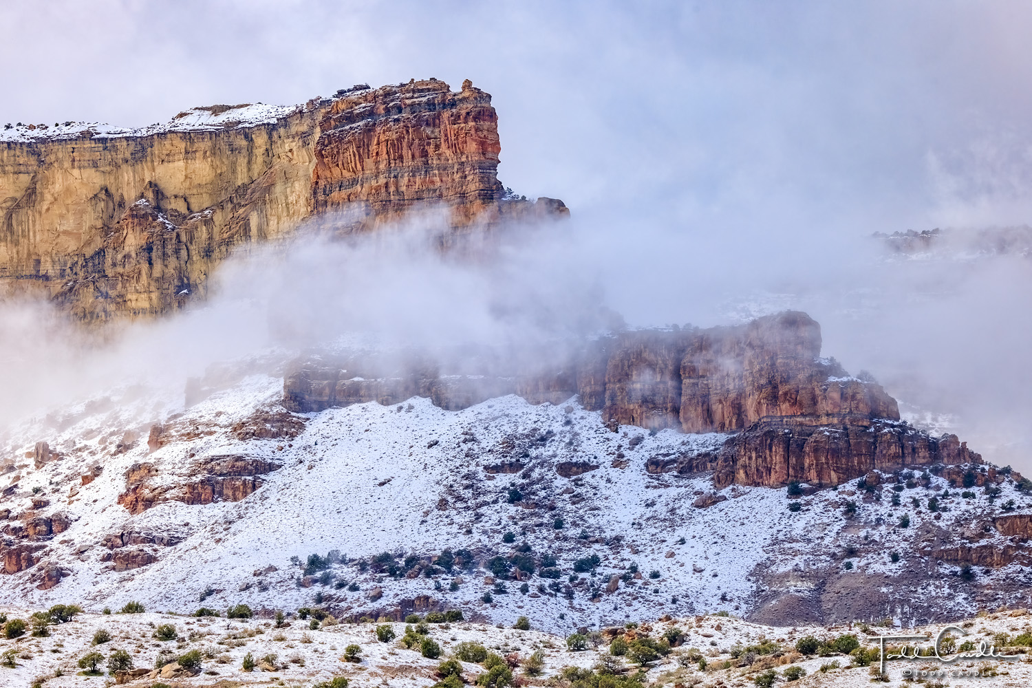 Clouds and fog part to reveal mesas as an early-spring snowstorm departs Colorado's rugged Western Slope canyon country.