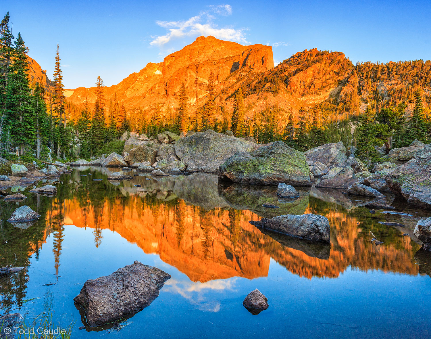 Flattop Mountain reflects in a rock-strewn tarn near the outlet of Lake Haiyaha at sunrise.