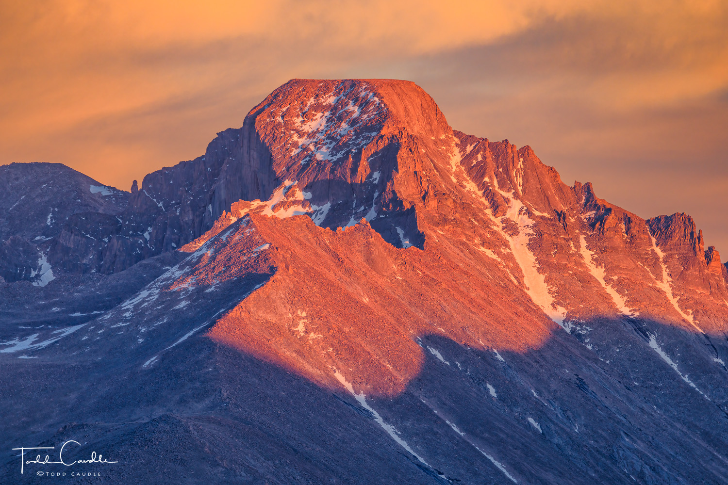 Alpenglow light paints Longs Peak in colorful hues at sunset.