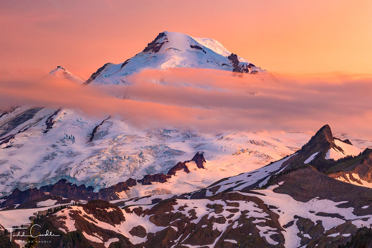 As the sun dips below the horizon, the sky glows with its warm hues over Mount Baker.