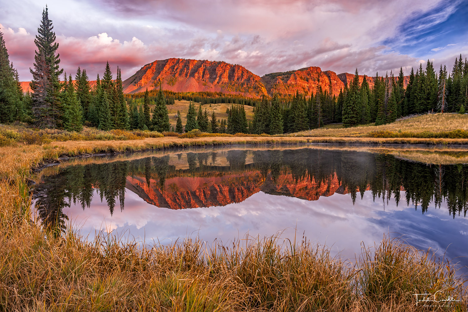 Alpenglow Mirror & Grasses Autumn grasses line a reflective tarn in the Flat Tops while the rising sun paints the peaks beyond in shades of red and orange...