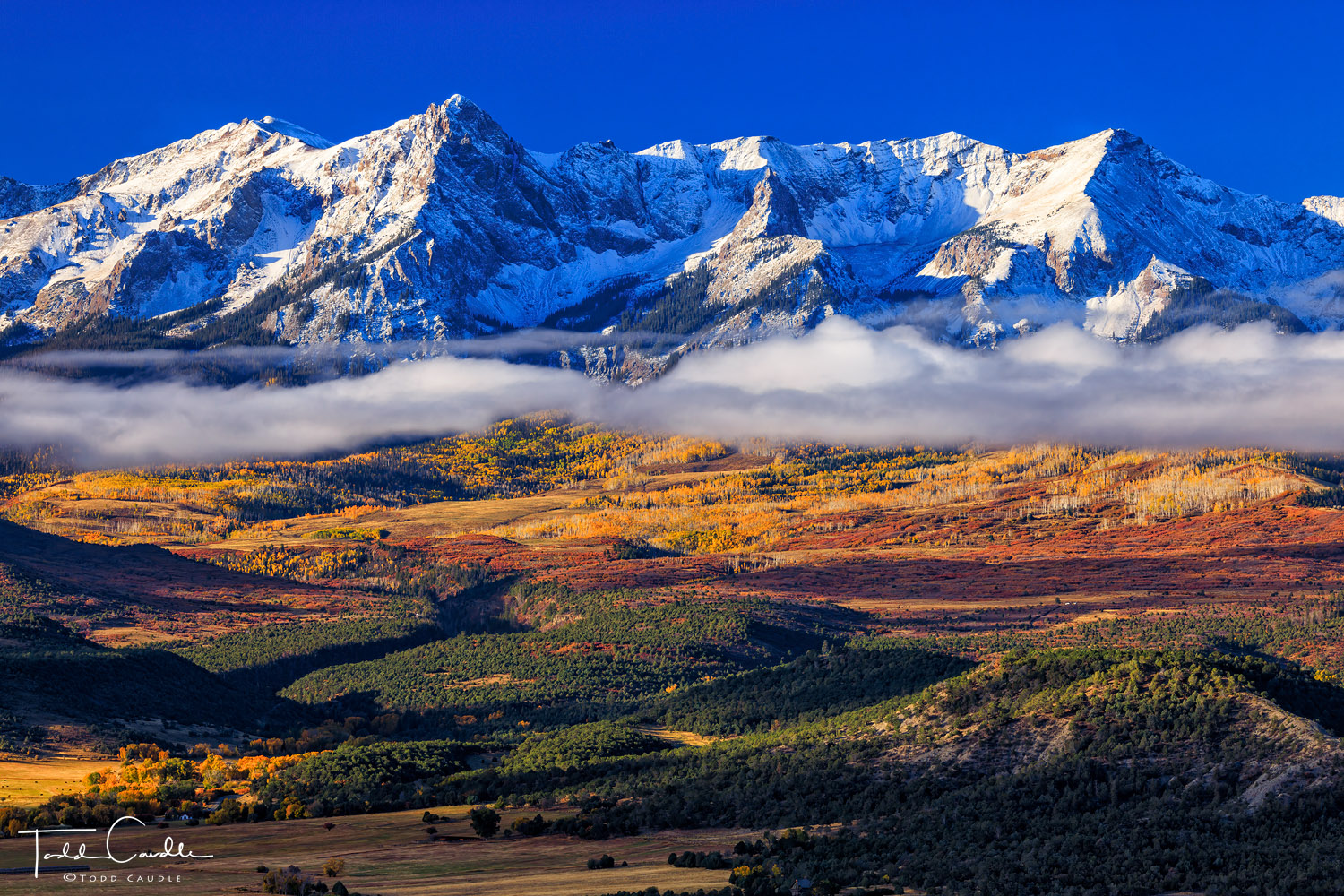 A fogbank drifts past peaks of the Sneffels Range on a sunny autumn morning. This cloud continued to grow and shift across the...